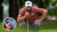 Jon Rahm lines up a putt whilst Rahm holds the Spanish Open trophy