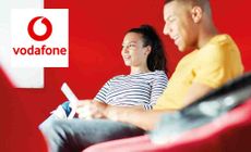 Vodafone logo placed over an image of two people sitting in a bright red room on phone