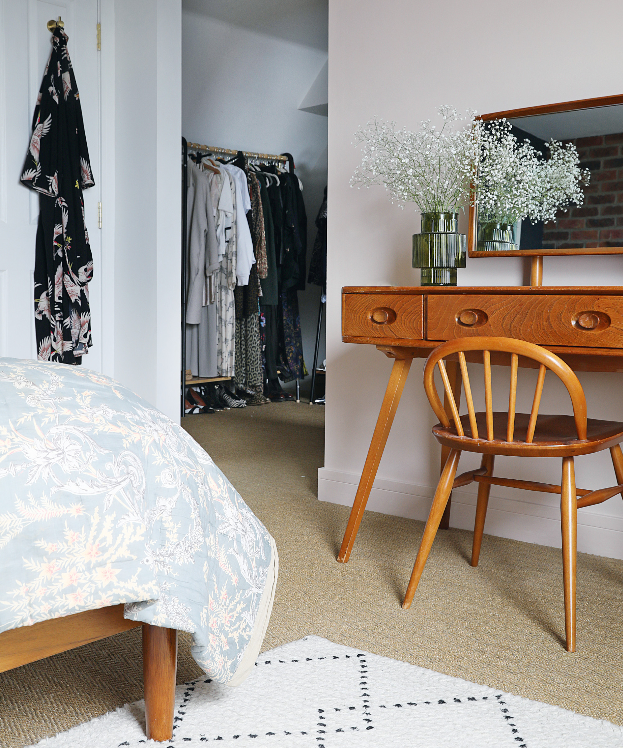 Bedroom with a visible dressing area around the corner containing a clothes rail
