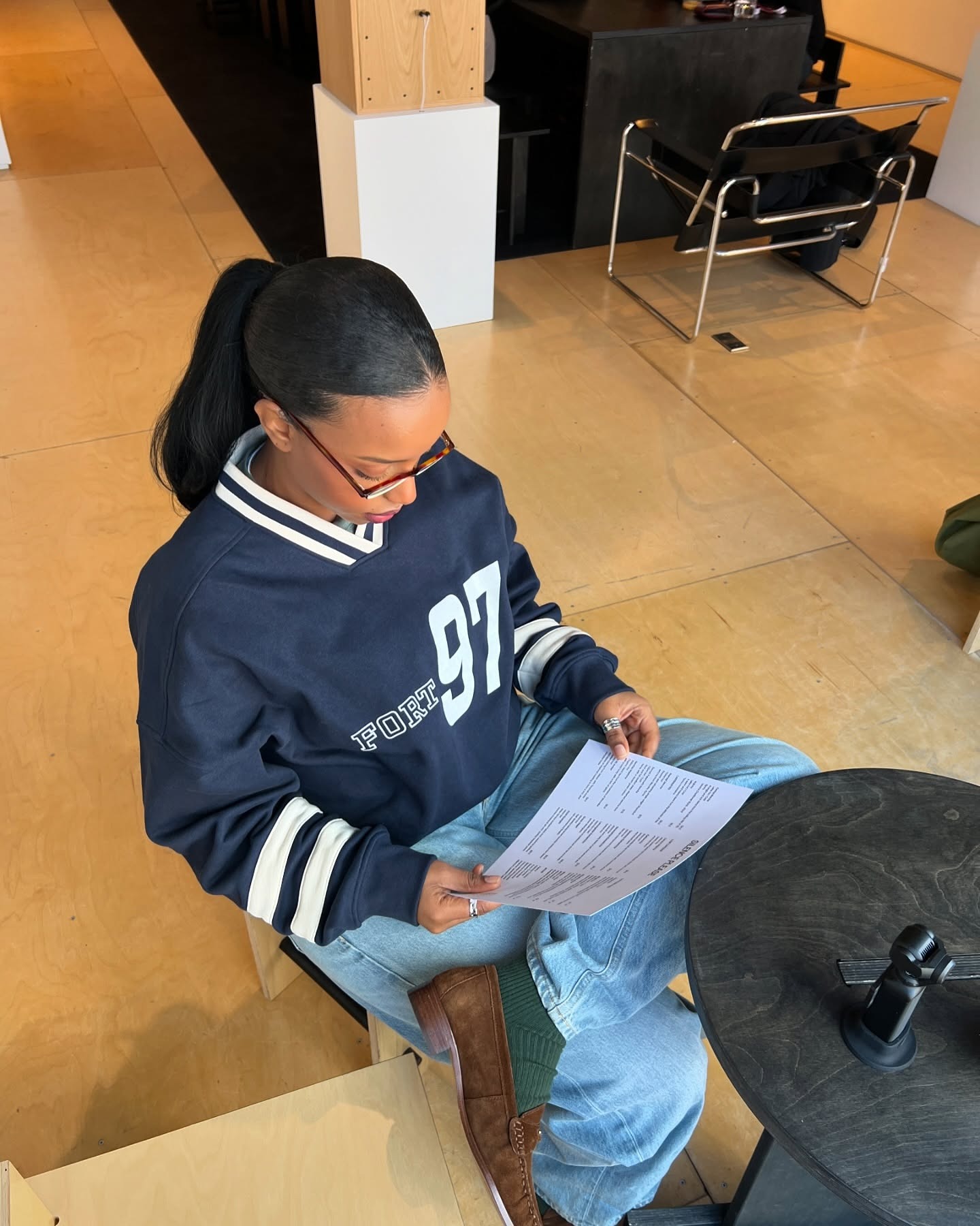 A woman reading a cafe menu with a sleek, shiny ponytail