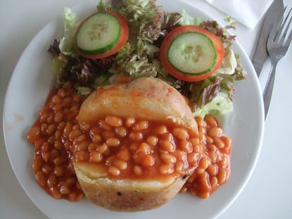 Baked potato, baked beans and salad arranged to look like a face