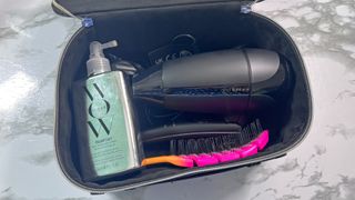 GHD Flight+ hair dryer in its case with other hair items