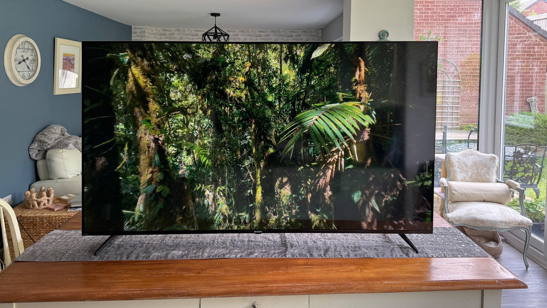 Sharp GK4245K 70-inch 4K TV on table in living room, on screen is jungle scene