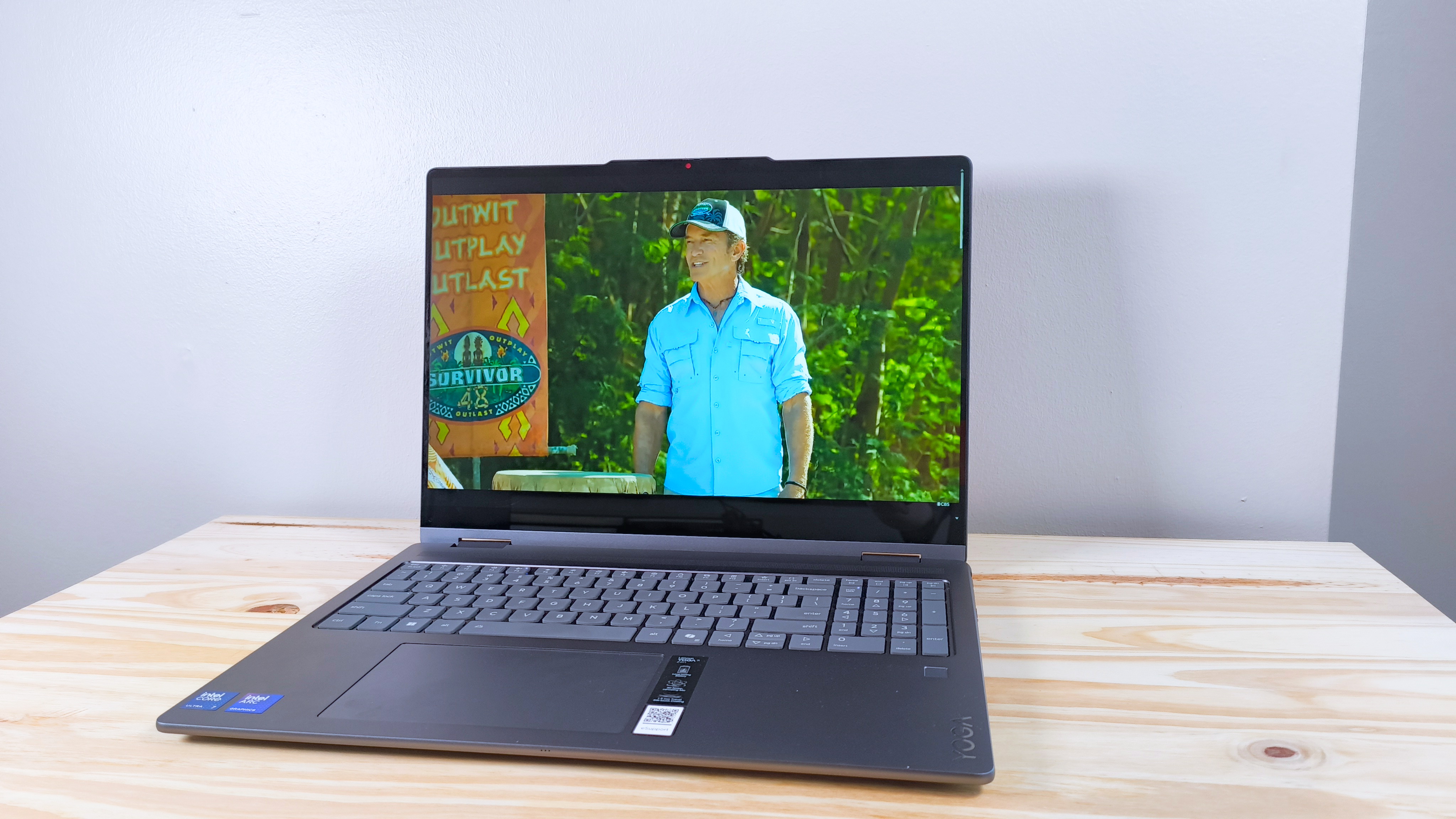 The Lenovo Yoga 7i 2-in-1 16 on a wood table playing an episode of Survivor 48 (CBS)