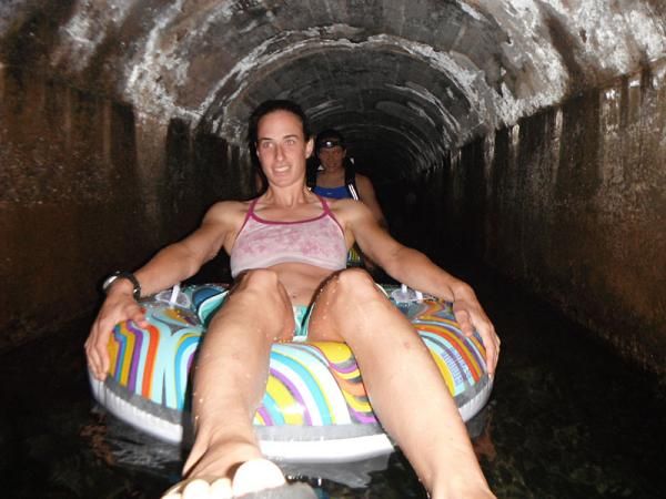 Lead Davison tubing down a sugarcane tunnel in Kauai