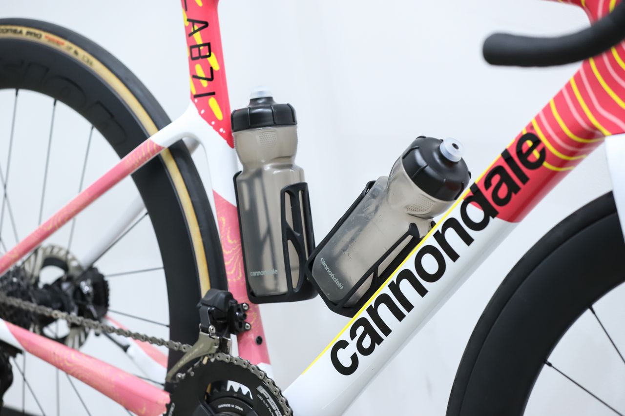 A team-edition Cannondale SuperSix Evo 4 stands against a white wall