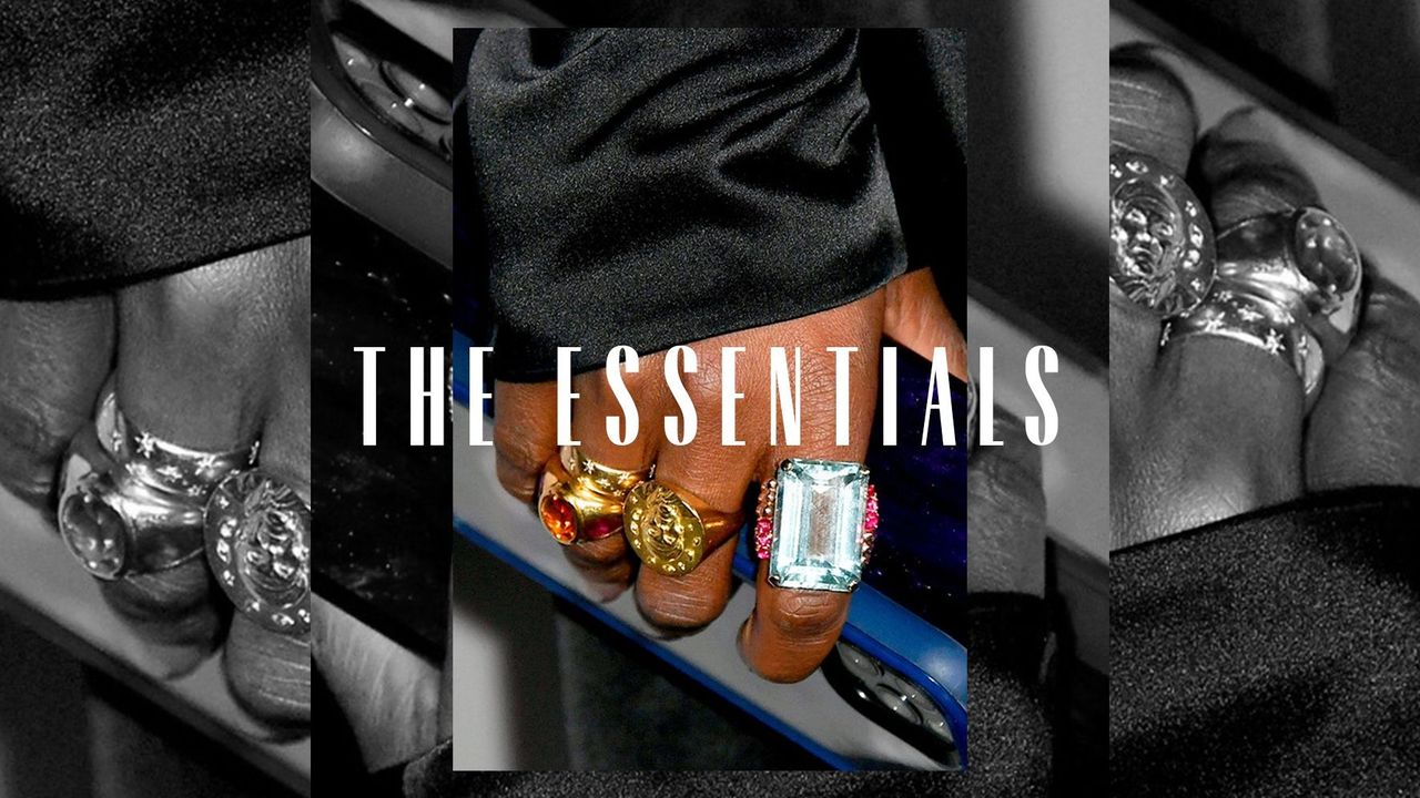 A hand wearing three chunky rings. Overlaid text reads, &quot;The Essentials&quot;