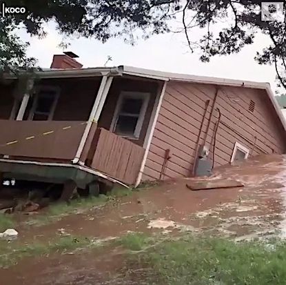 A house in Oklahoma slides into a flooded river