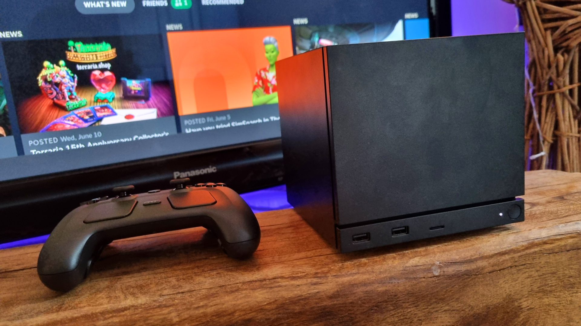 A Steam Machine and Steam Controller, side-by-side in front of a TV