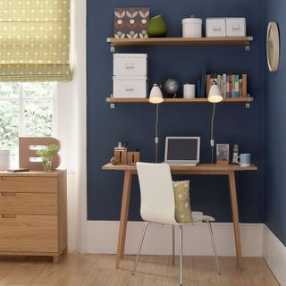 home office with blue wall and wooden shelves and desk with chair and wooden floor