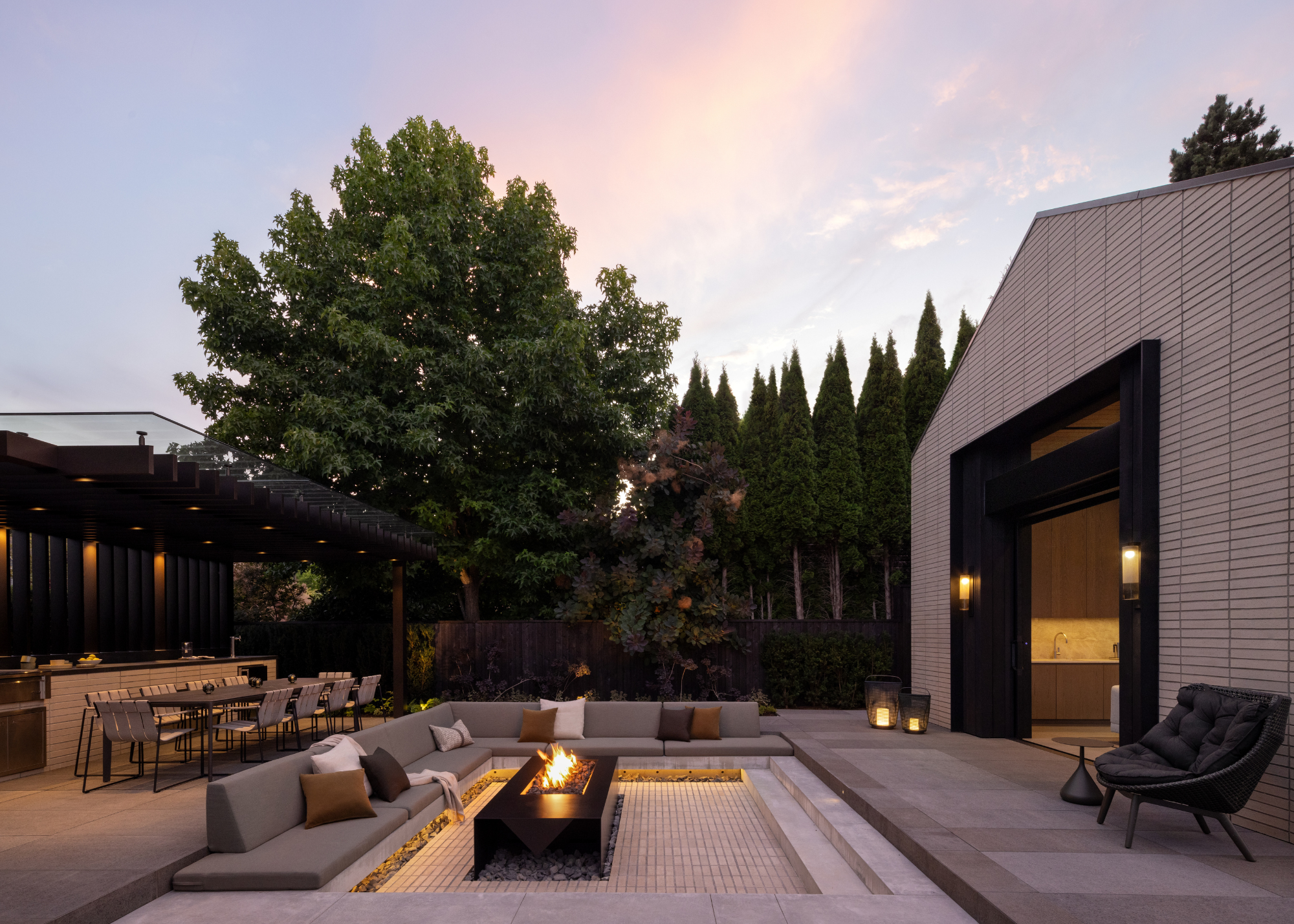 sunken seating area around a firepit in a concrete garden surrounded by forest