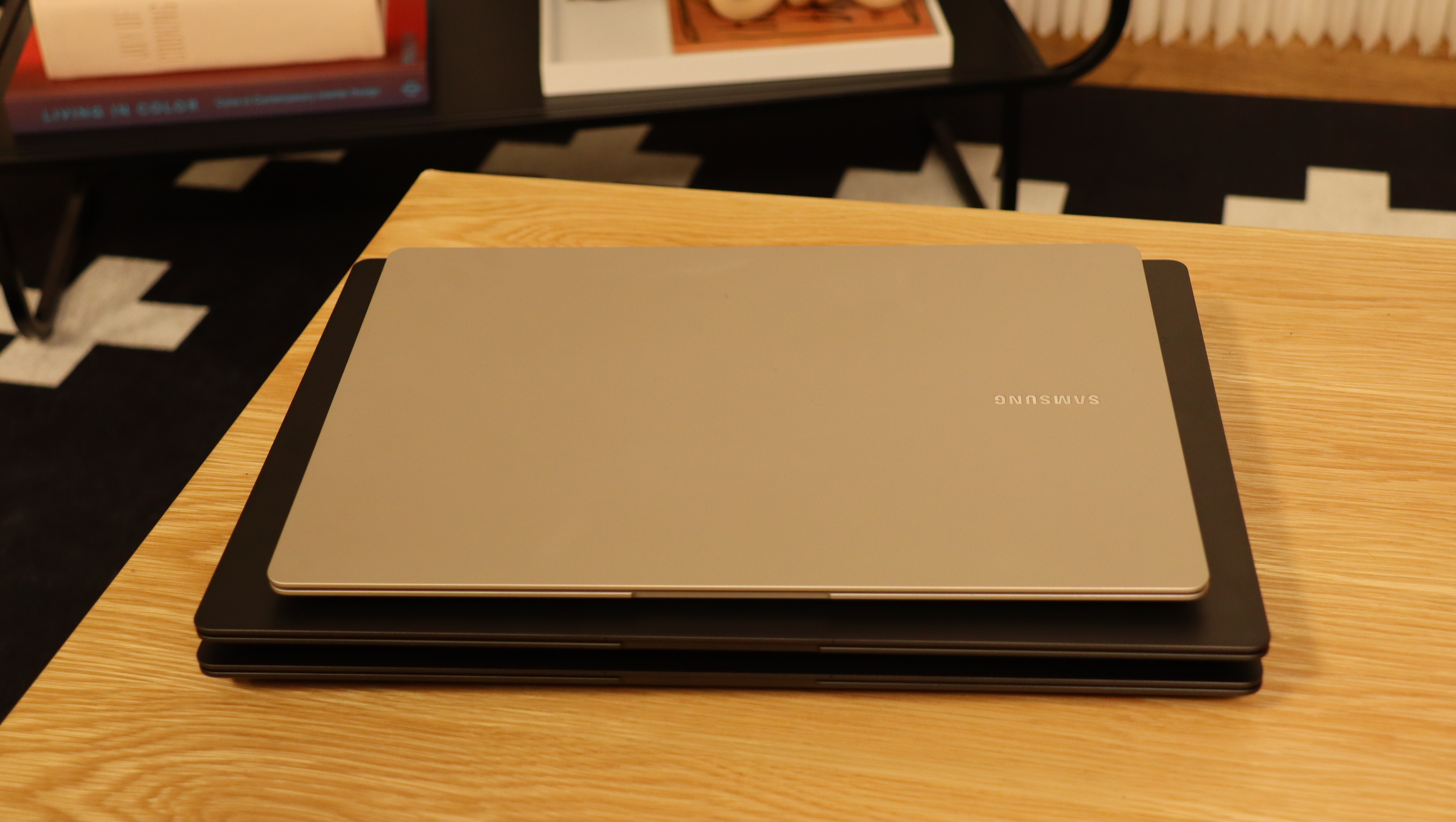 Three Samsung Galaxy Book3 piled up on a wooden table