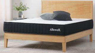 The Allswell Mattress with no bedding in a clean, light-colored bedroom.