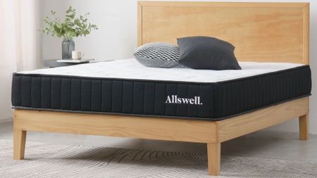 The Allswell Mattress with no bedding in a clean, light-colored bedroom.