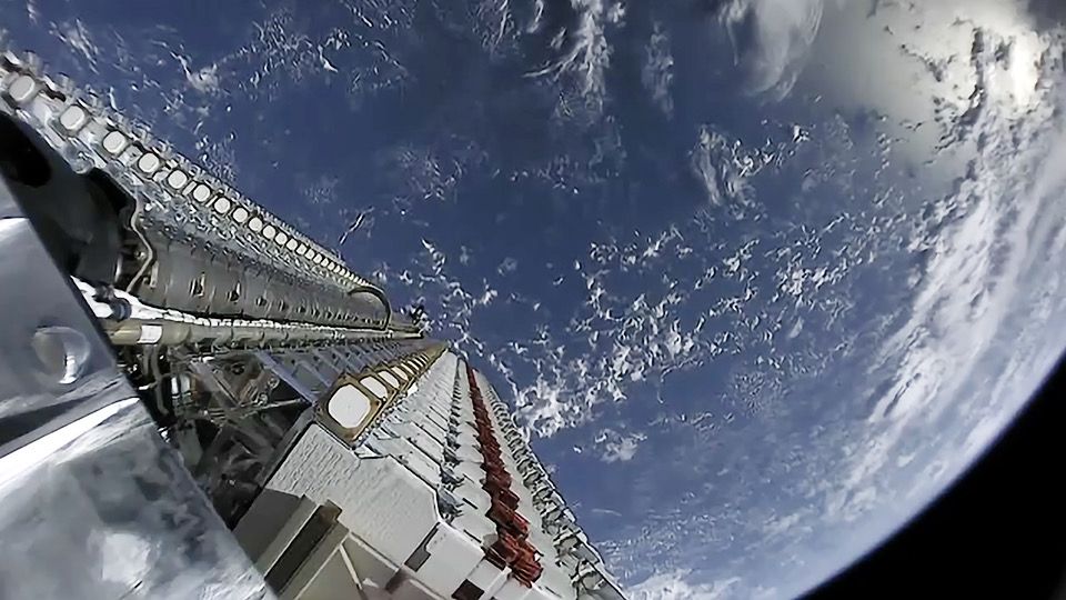 A view of SpaceX&#039;s first 60 Starlink satellites in orbit, still in stacked configuration, with the Earth as a brilliant blue backdrop on May 23, 2019.