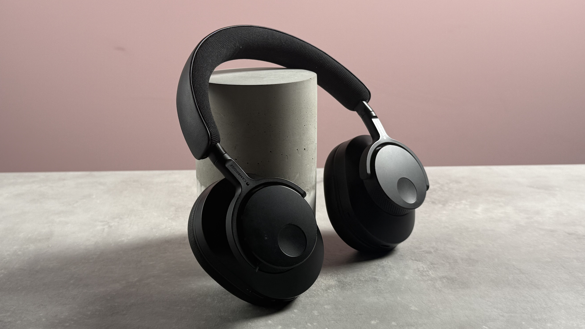 The Cambridge Audio Melomania P100 propped up at a 3/4s angle in front of a pink background.