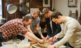 group of men cutting up cake