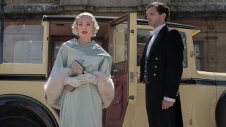 Laura Haddock steps out of a car next to Michael Fox in Downton Abbey A New Era.