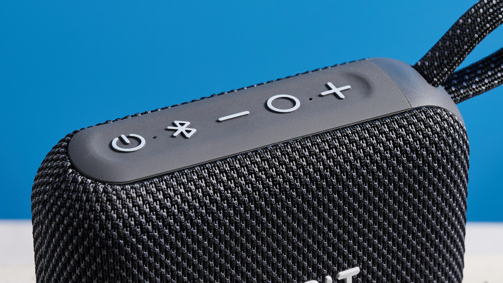 The Tribit PocketGo speaker in black photographed on a blue background.