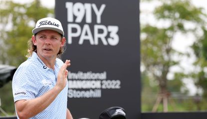 Smith waves to the crowd in front of an LIV Golf logo