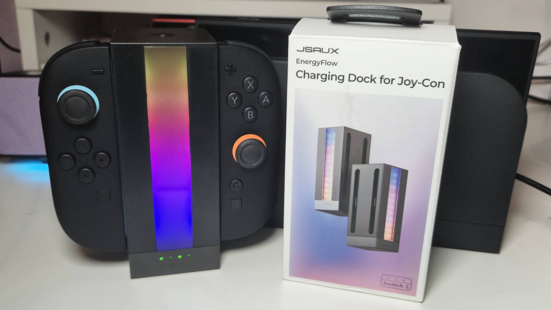 Photo of two Switch 2 Joy-Con sitting in a black RGB tower, with its box sitting to its right.