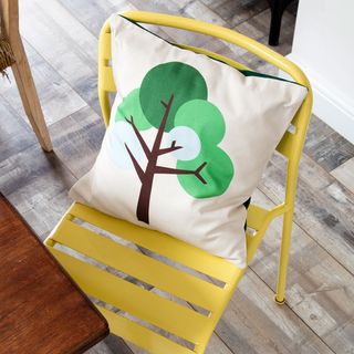 yellow chair with tree texture on cushion and tiled flooring