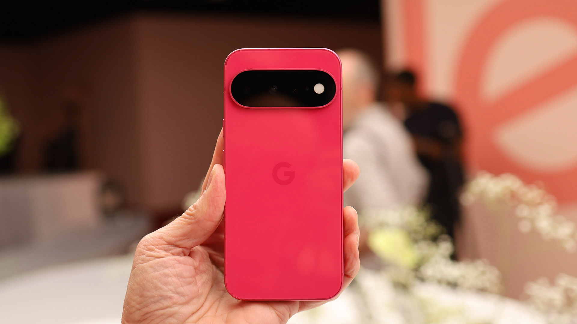 Google Pixel 11 Hands On - the Hibiscus color being held in a man's hand