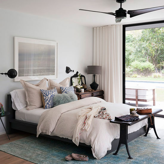 bedroom with bed artwork on the wall and silk turquoise rug