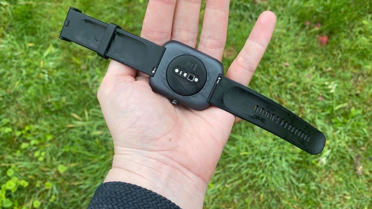 A hand holding an AmazFit Bip 3 Pro
