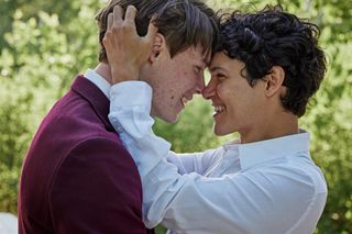 Edvin Ryding and Omar Rudberg lean in for a kiss and smile at each other in 'Young Royals.'