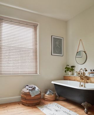 faux wooden bathroom blinds in cream bathroom with rolltop bath