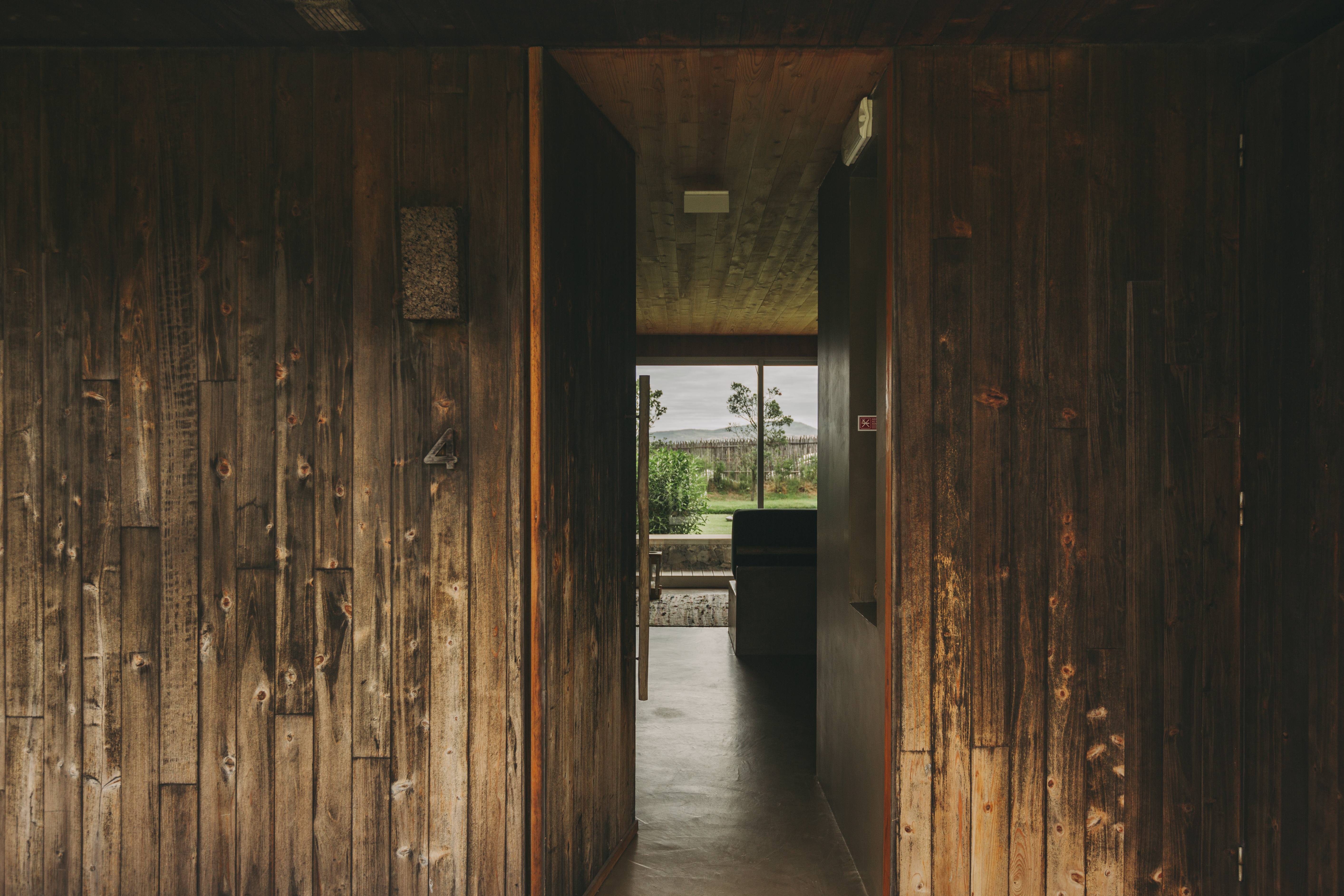 A wrapped-in-wood hotel suite boasts a modern rustic, dimly lit atmosphere.