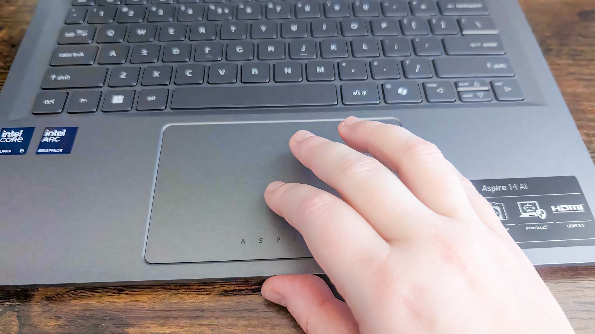 A hand on the Acer Aspire 14 AI's touchpad. 