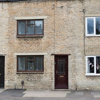 house with brick wall and venetian blind windows