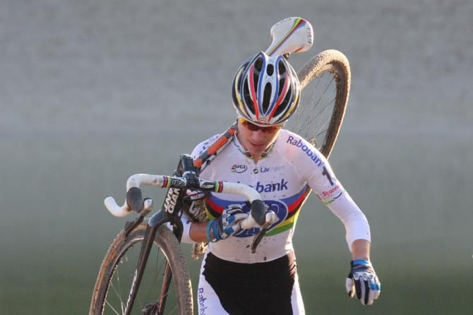 Marianne Vos with her bike over her shoulder
