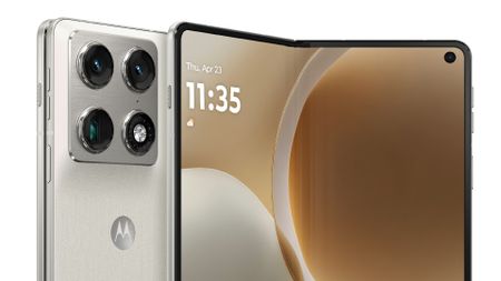 A close-up view of a white Motorola Razr folding phone featuring a prominent silver camera island with four lenses and a large, partially unfolded internal display.