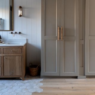 bathroom with shiplap walls, rustic style vanity, cabinets, hexagon tiles teamed with wooden floor