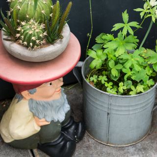 A garden with a gnome table and a planter made from a abucket
