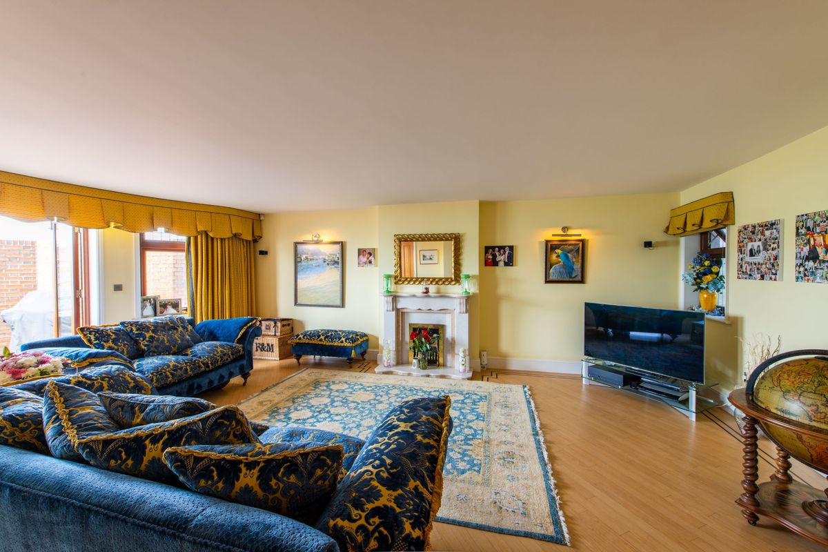 The living room has wooden flooring and tv with a fireplace next to it