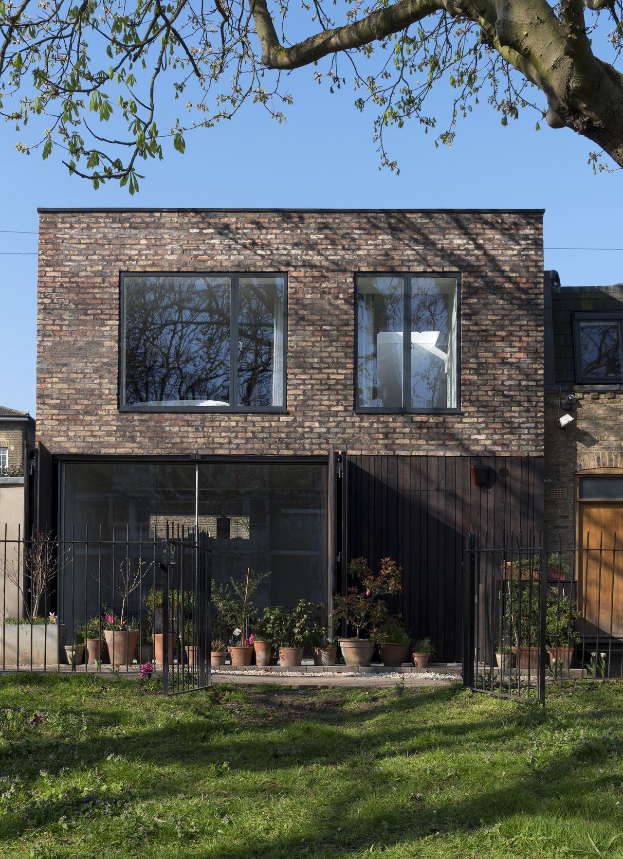 brick clad self build with larch shutter doors