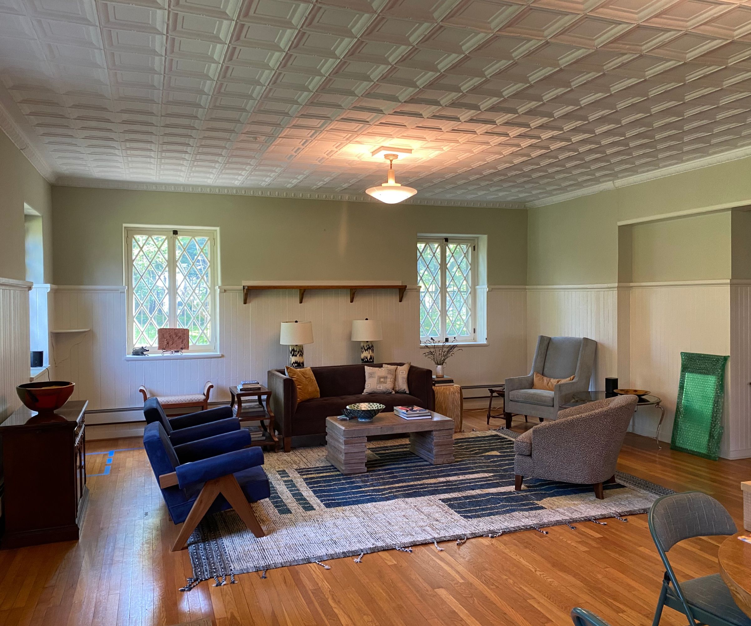 Before pictures of a living room with tin ceiling and wooden flooring