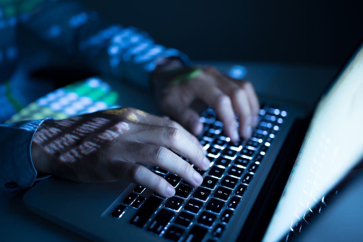 Man typing on laptop.