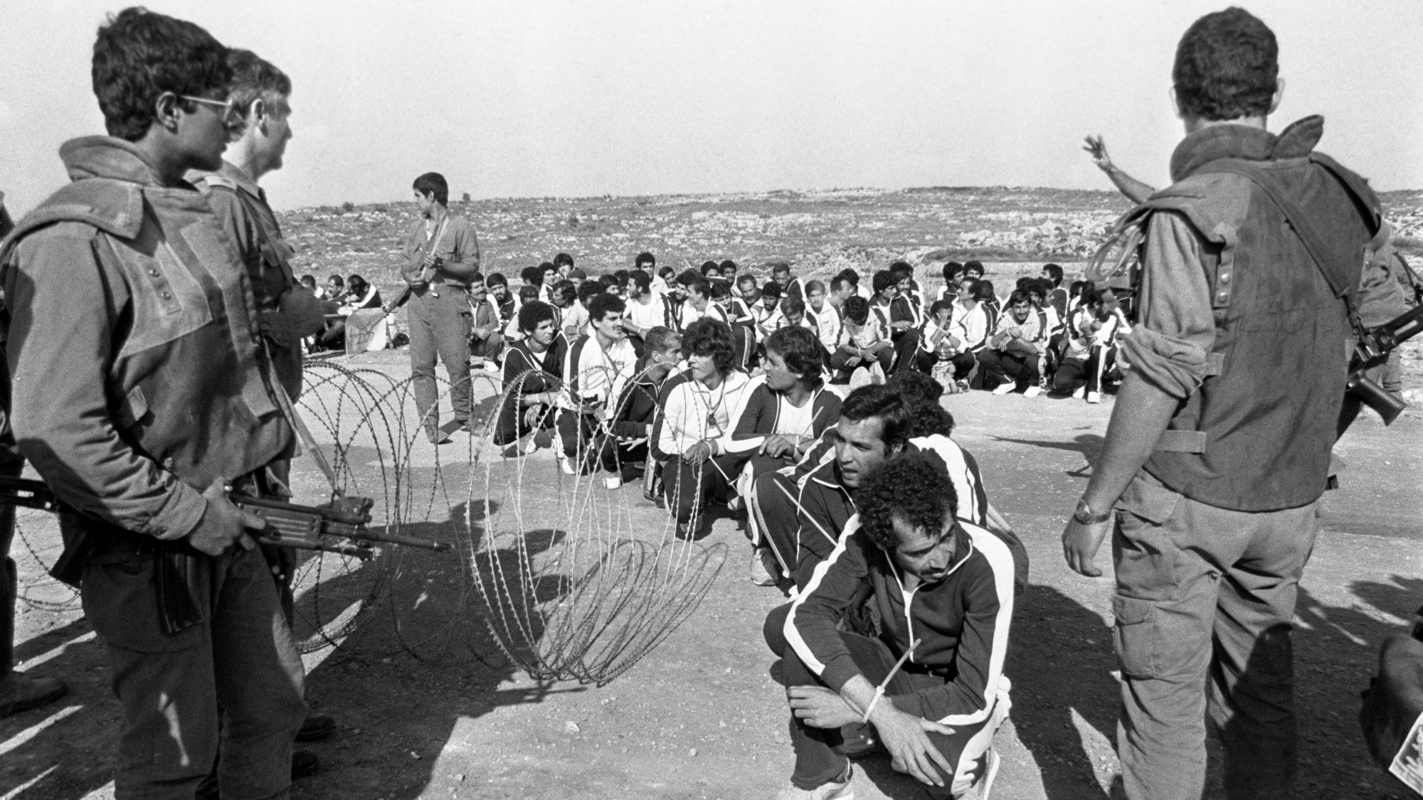 Israeli soldiers guard Palestinians waiting to be released in the 1983 prisoner swap