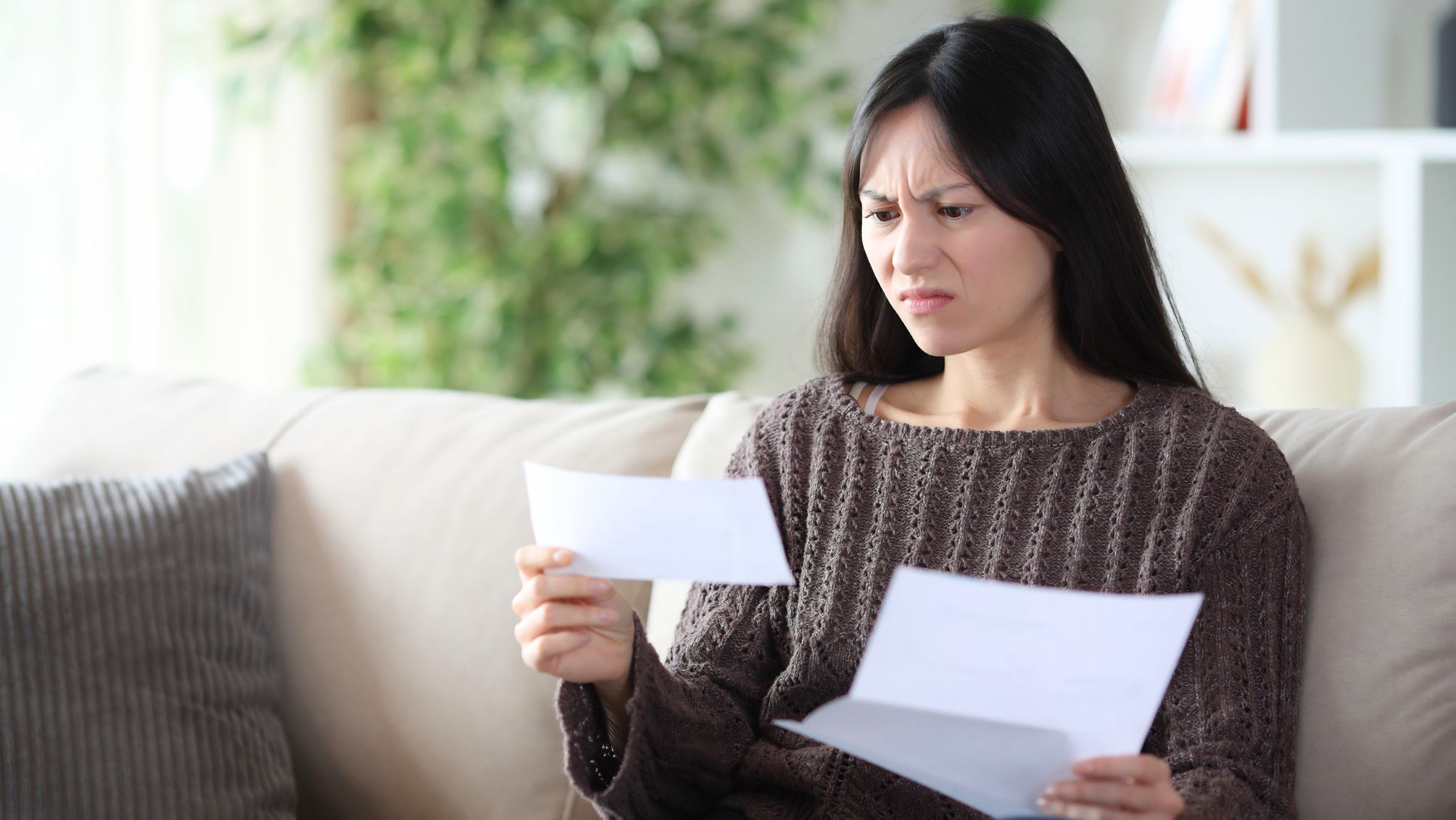 A woman reviewing her bank statement, disappointed with her interest earnings. 