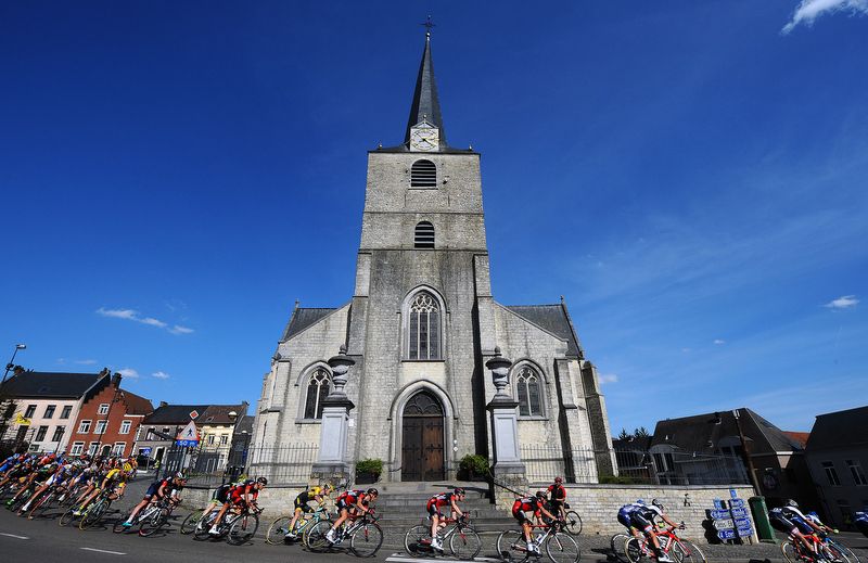The peloton passes by a church