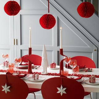red and white Christmas themed dining table next to white staircase
