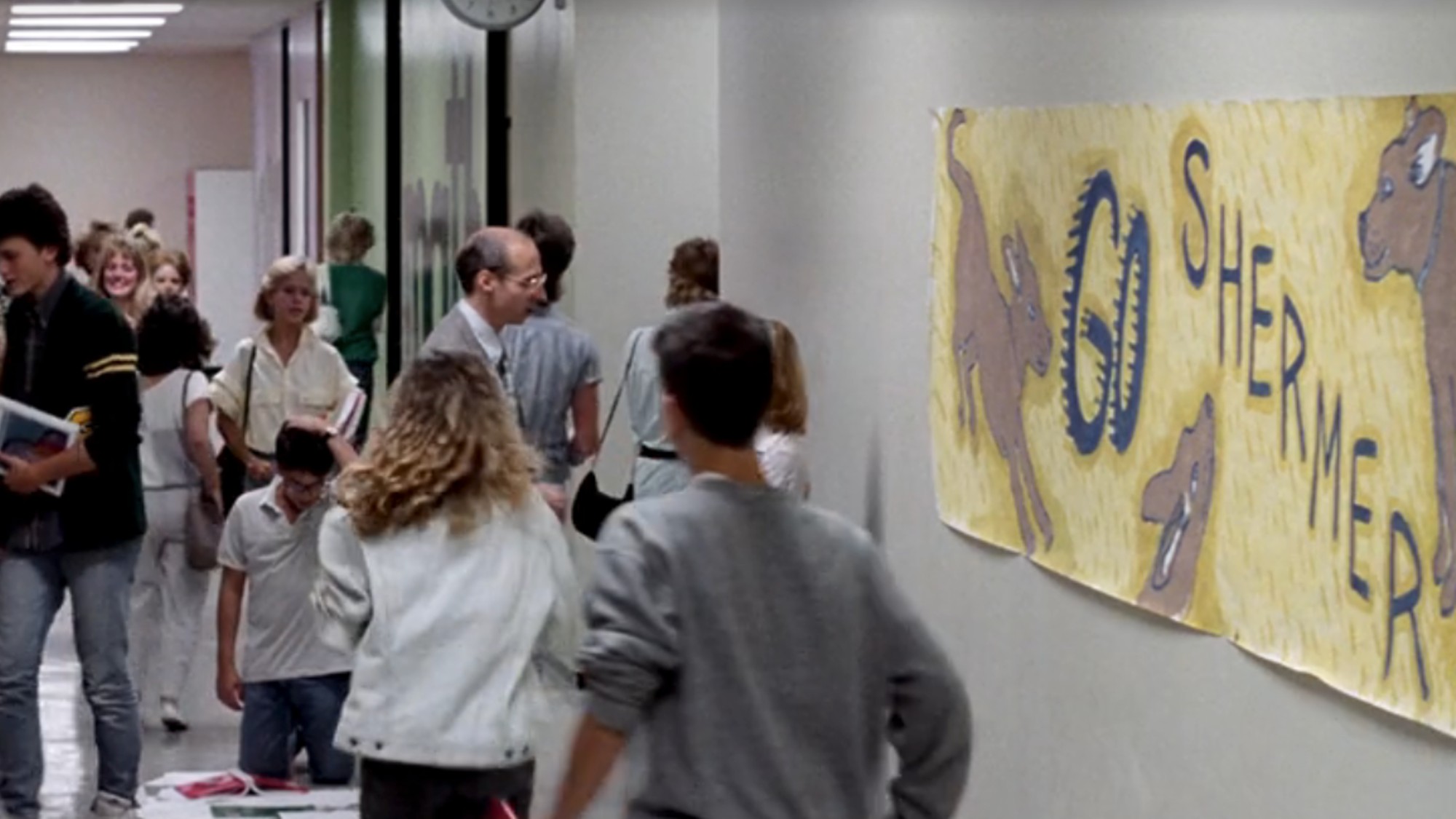 A hallway in the high school in Ferris Bueller's Day off with a sign on the wall reading &amp;quot;Go Shermer&amp;quot;