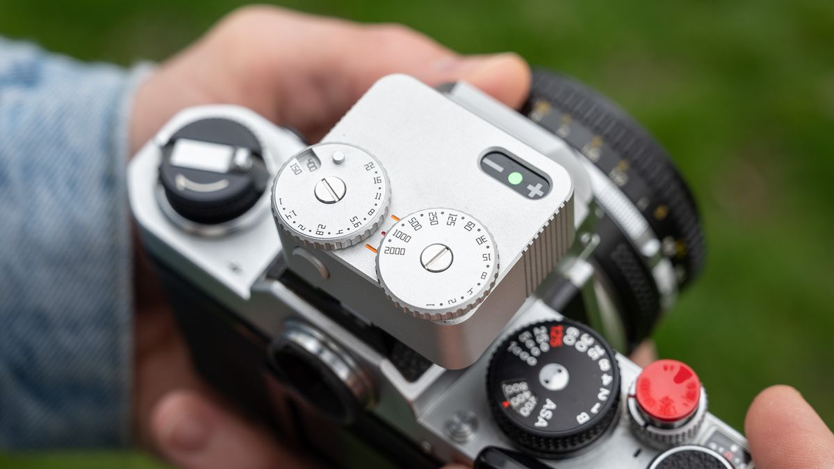 Close-up of TTArtisan Light Meter II on a Nikon FM being held out in the field