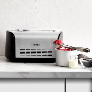 Vonchef lifestyle ice cream maker on a marble kitchen counter with a bowl of ice cream and various ingredients.