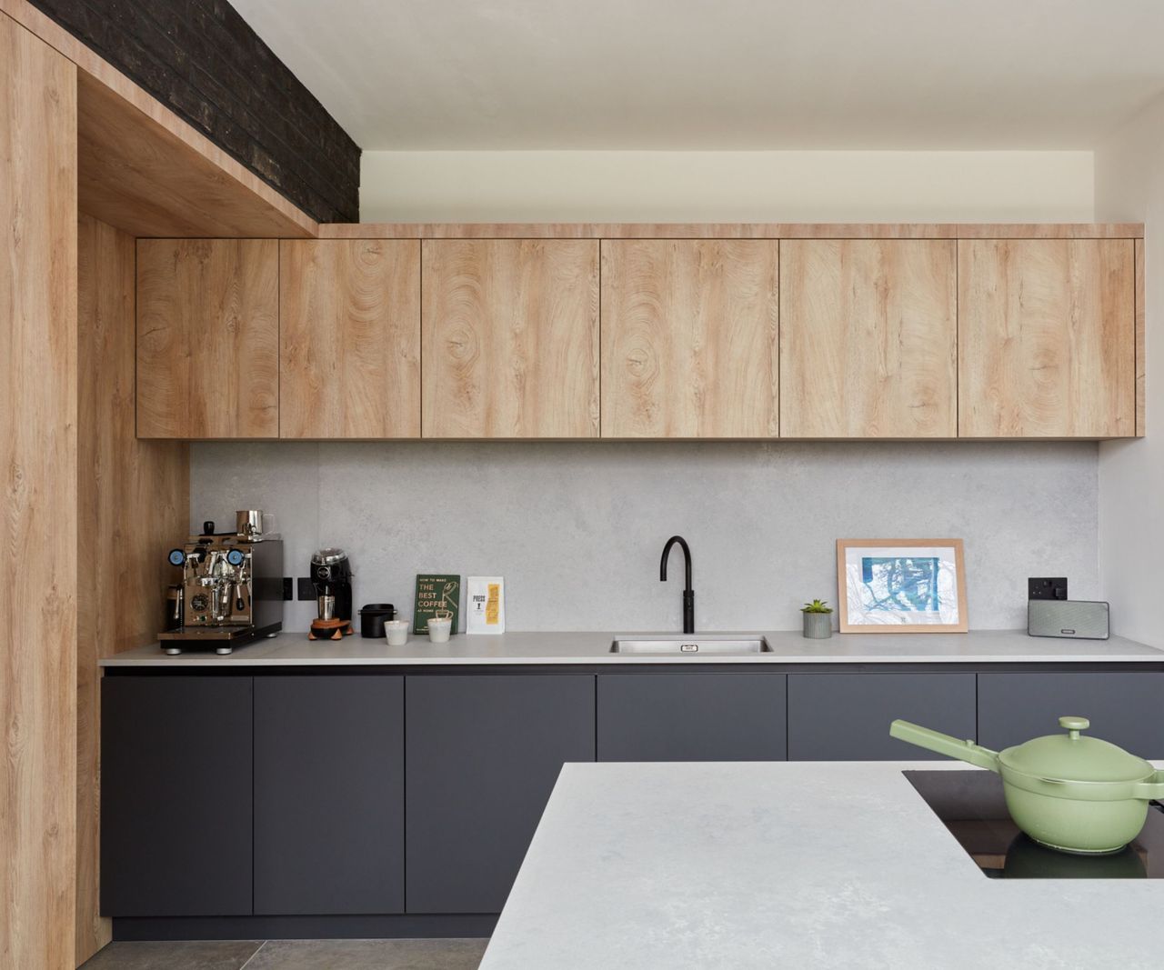 A large kitchen with wood and dark blue cabinets and concrete countertops